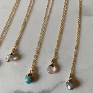 Gemstone Drop Necklaces Saskatoon. Row of oval shaped gemstone pendents on gold chains