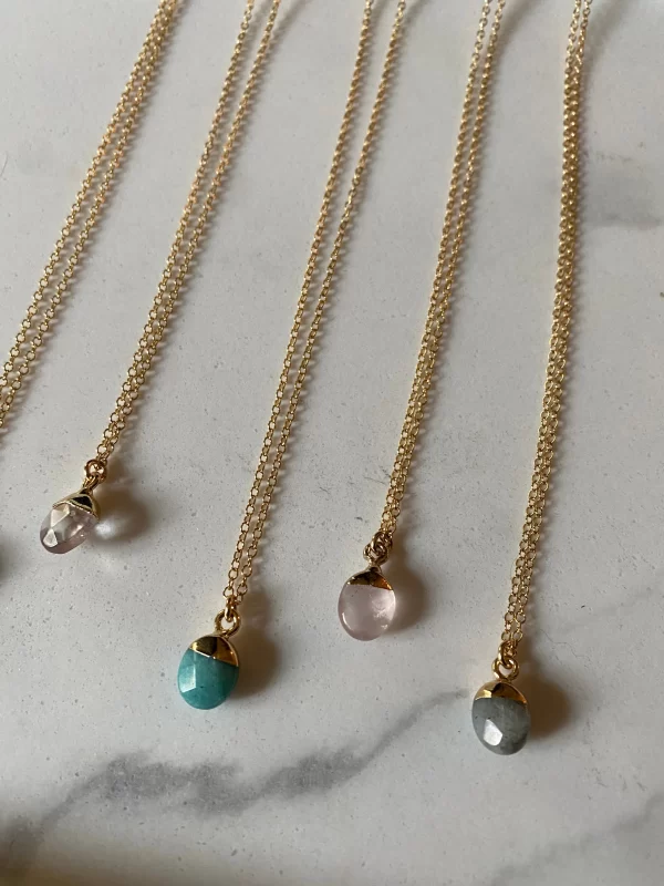 Gemstone Drop Necklaces Saskatoon. Row of oval shaped gemstone pendents on gold chains