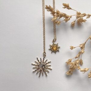sun pendant necklaces on gold and silver chains.